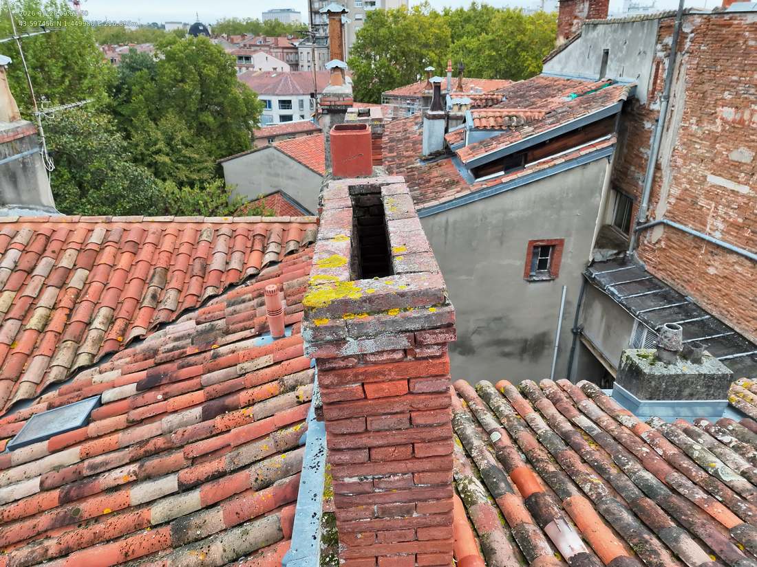 Souche de cheminée en briques sur une toiture en tuiles