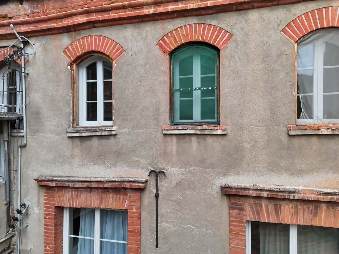 Façade sur cour avec fenêtres à arcs en brique