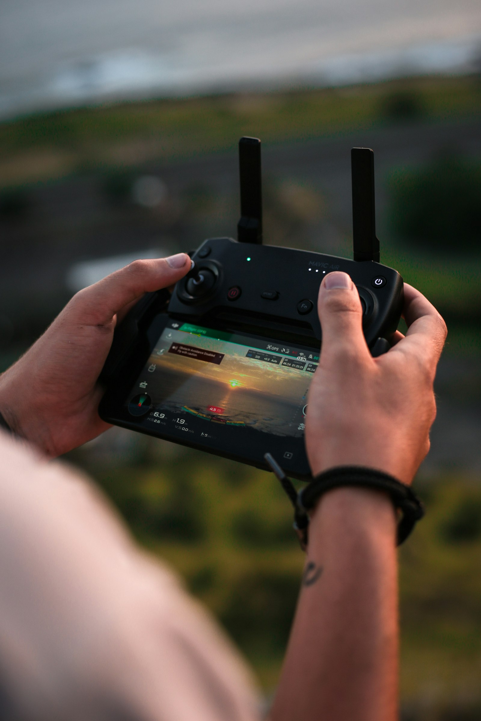 Télépilote tenant la radiocommande d'un drone sur le terrain